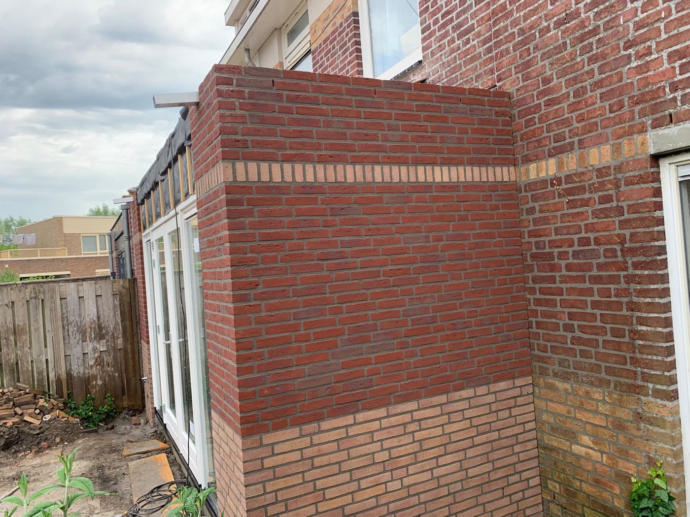 Gemetselde aanbouw van rode en gele baksteen