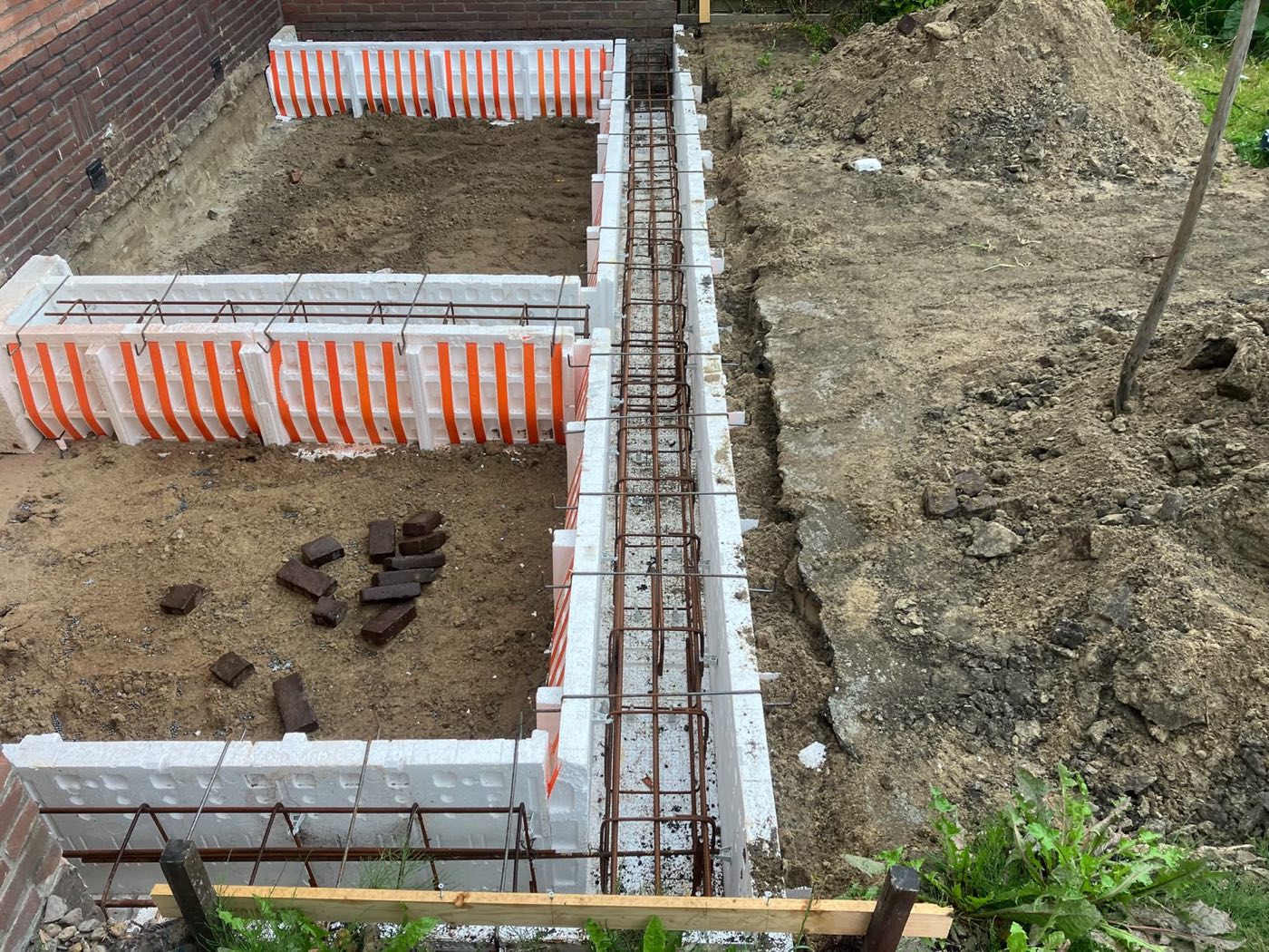 Fundering van een uitbouw: bekisting met wapening in de grond